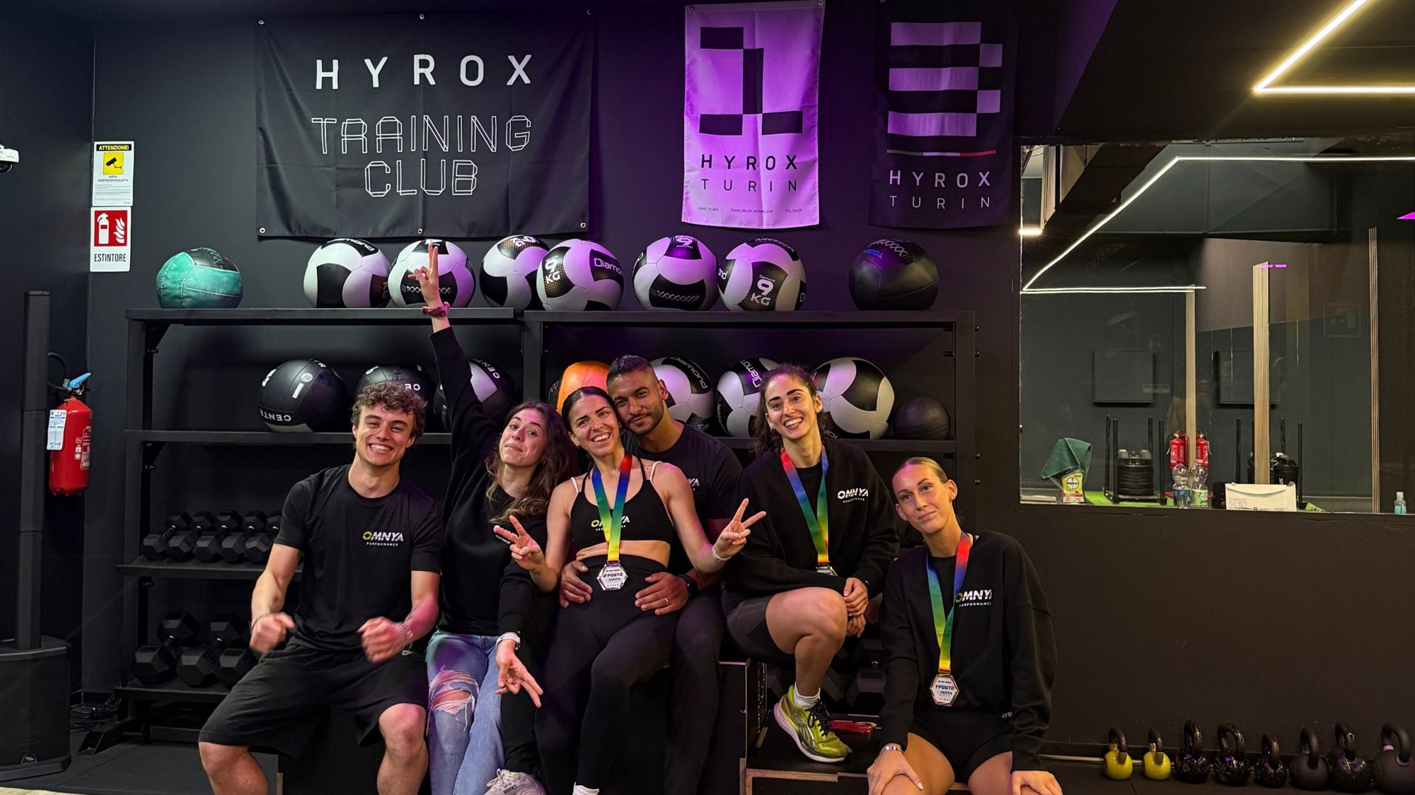 Il team OMNYA Performance davanti al banner HYROX Training Club